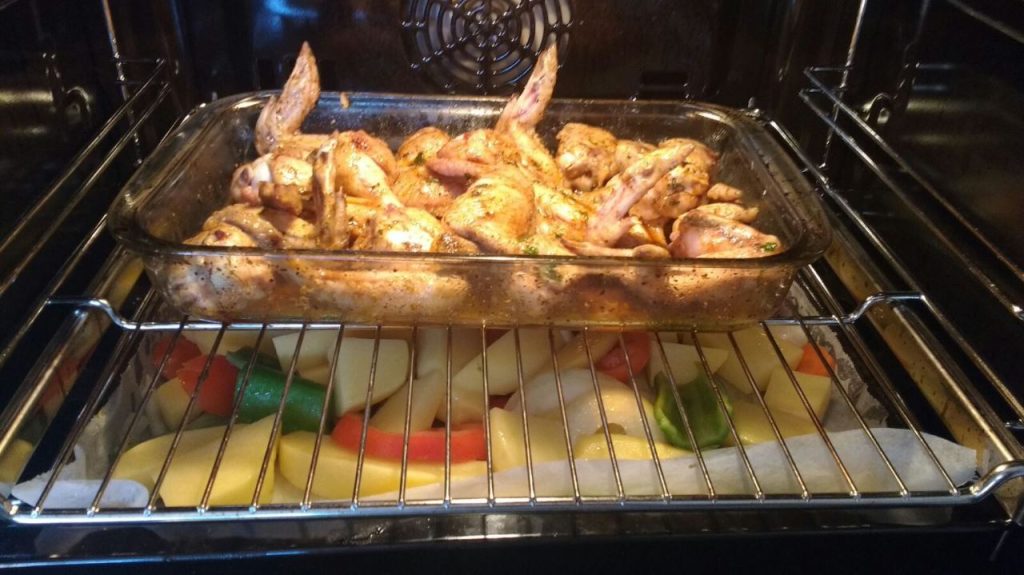 Un plato de pollo y verduras al horno.